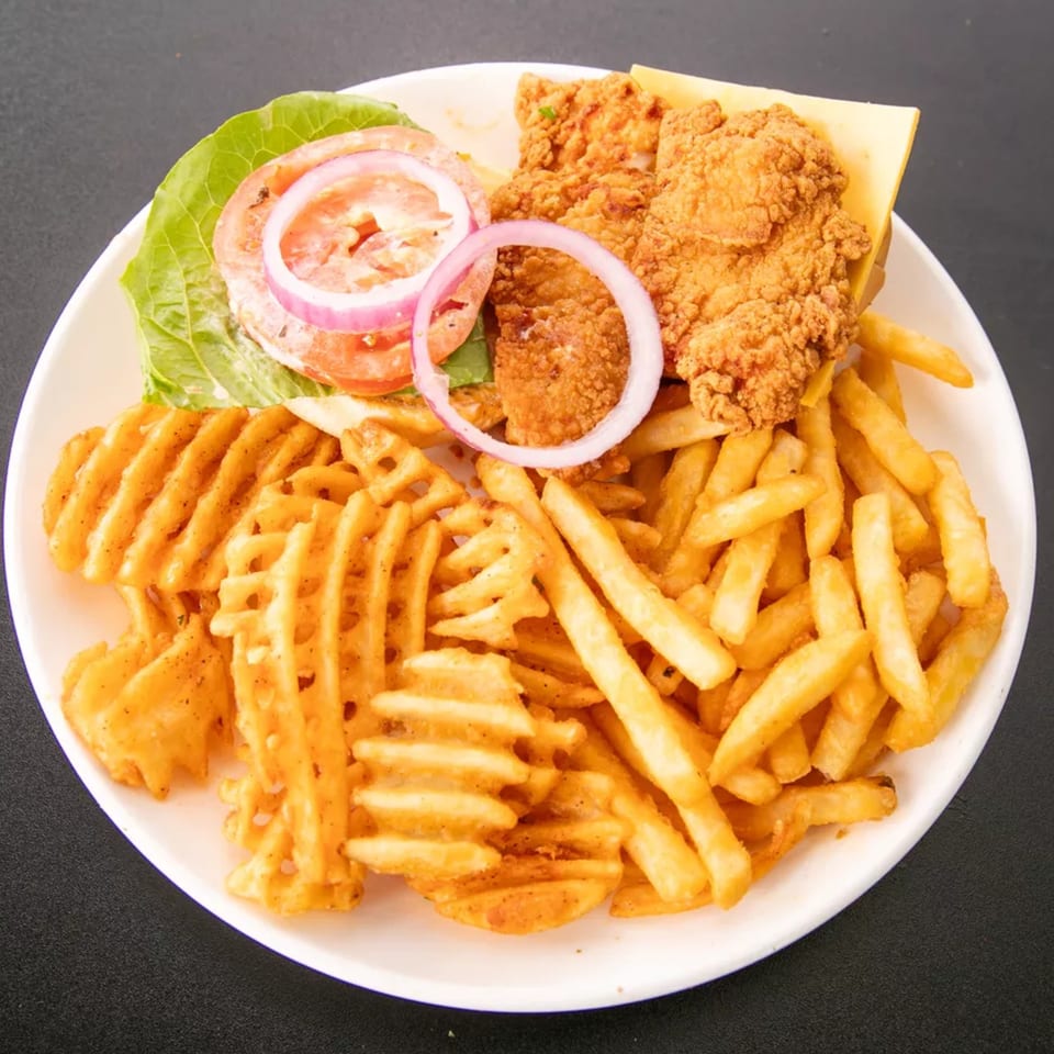 Crispy fried chicken sandwich with lettuce, tomato, onion, and cheese, served with waffle and regular fries.
